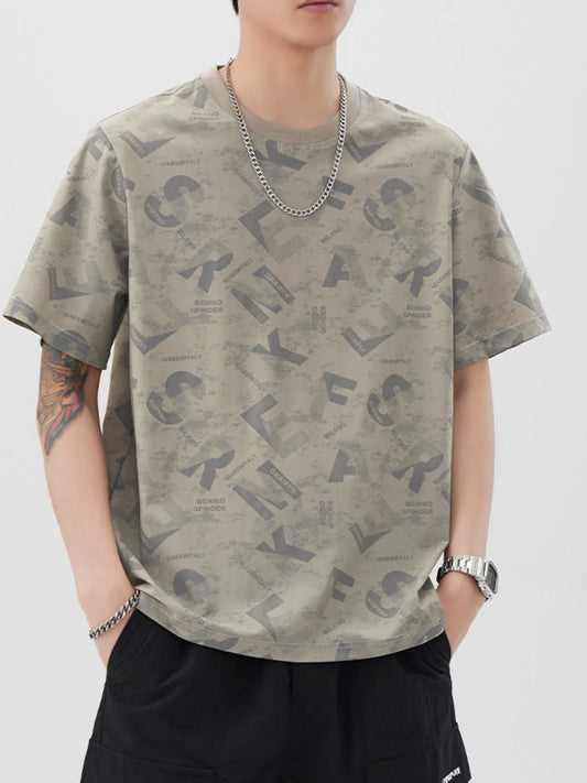Person wearing a patterned t-shirt with letters on a plain background