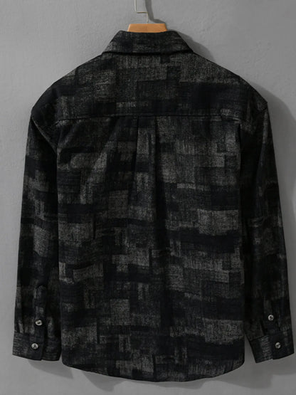 Black and gray plaid shirt on a hanger against a gray background