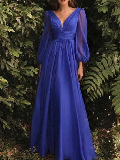 Woman wearing a blue evening gown against a green leafy background
