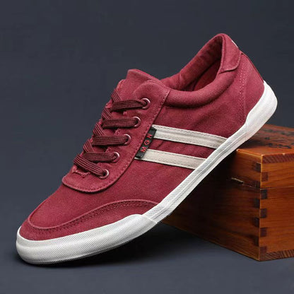 Red sneaker with white stripes on a wooden block against a dark background