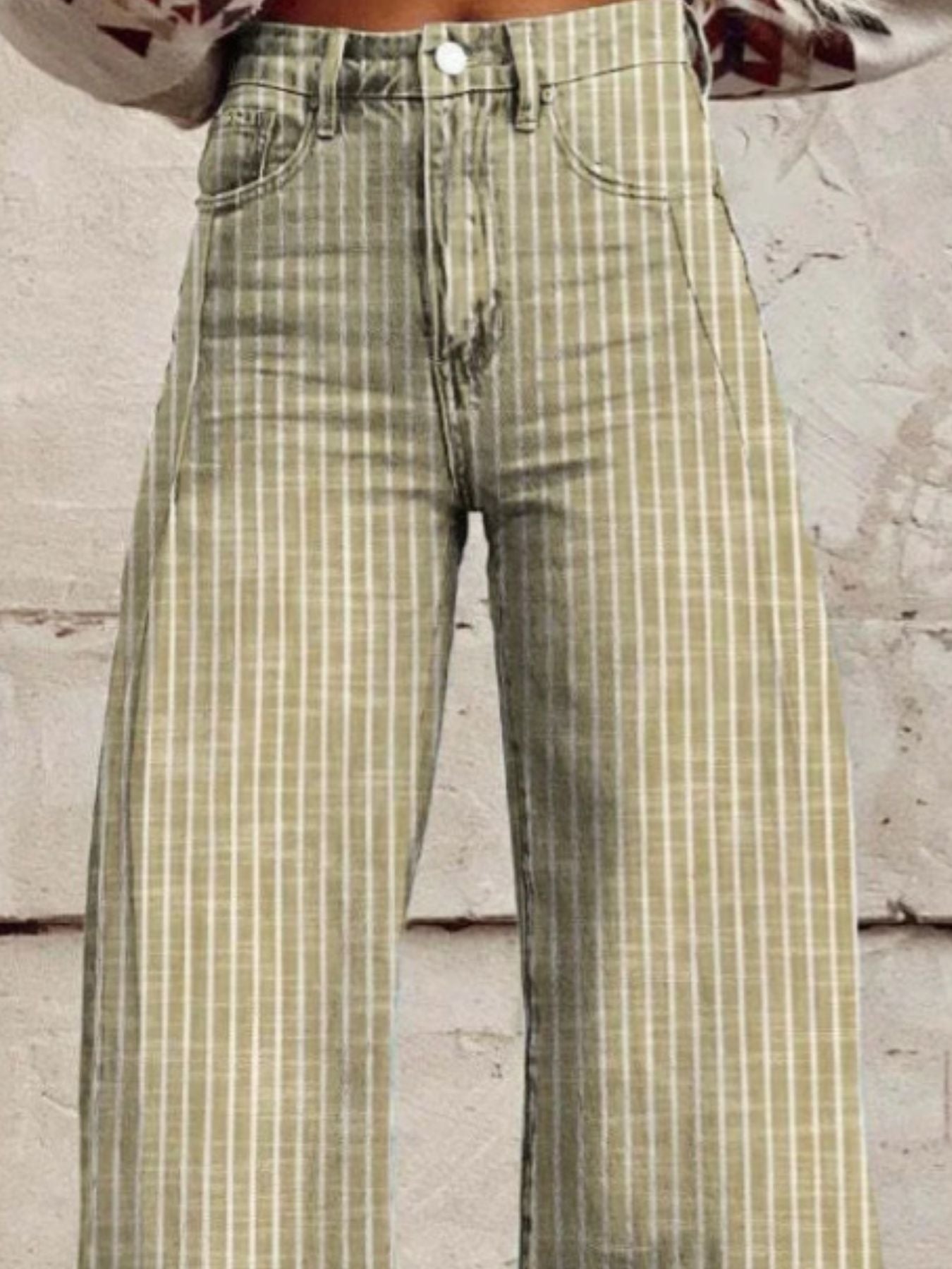 Green and beige checkered pants worn by a person against a light-colored wall.