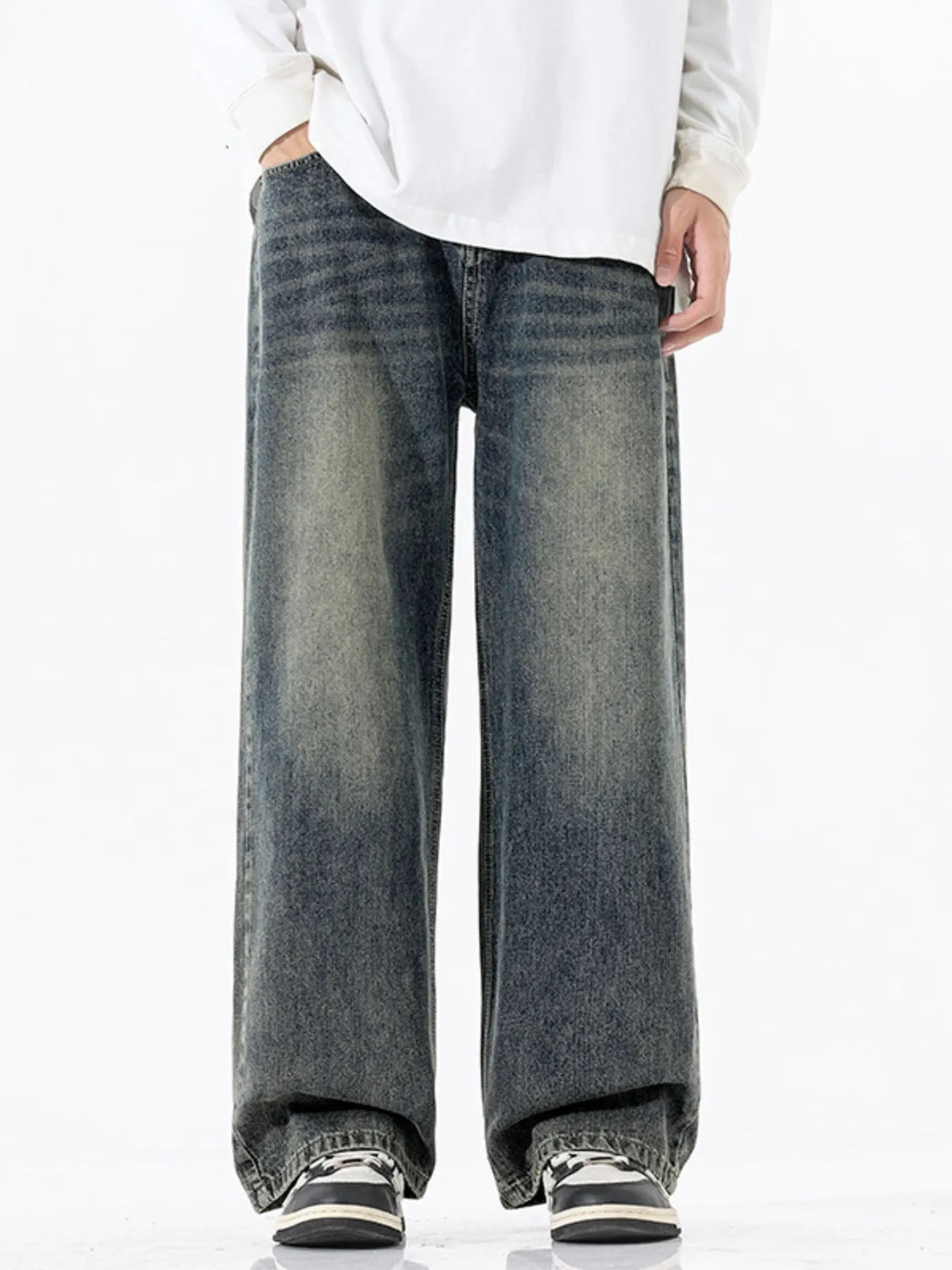 Person wearing wide-leg jeans and a white shirt on a white background