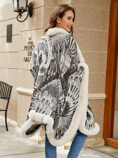 Woman wearing a patterned coat with white fur trim in front of a building.