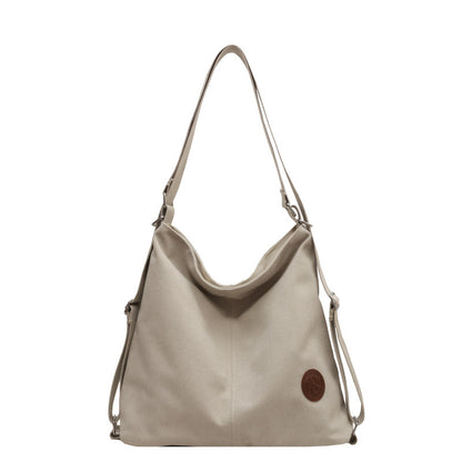Beige handbag with a brown leather patch on a white background
