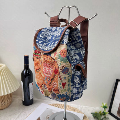 Colorful bag with elephant design on a mannequin stand against a neutral background