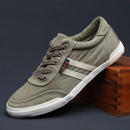 Green sneaker with white sole on a dark background
