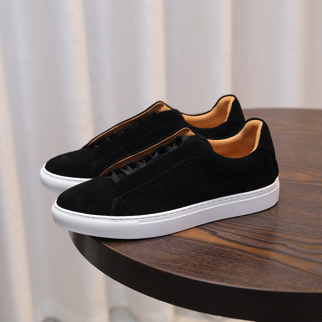 Black sneakers with white soles on a wooden table
