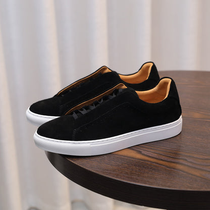 Black sneakers with white soles on a wooden table