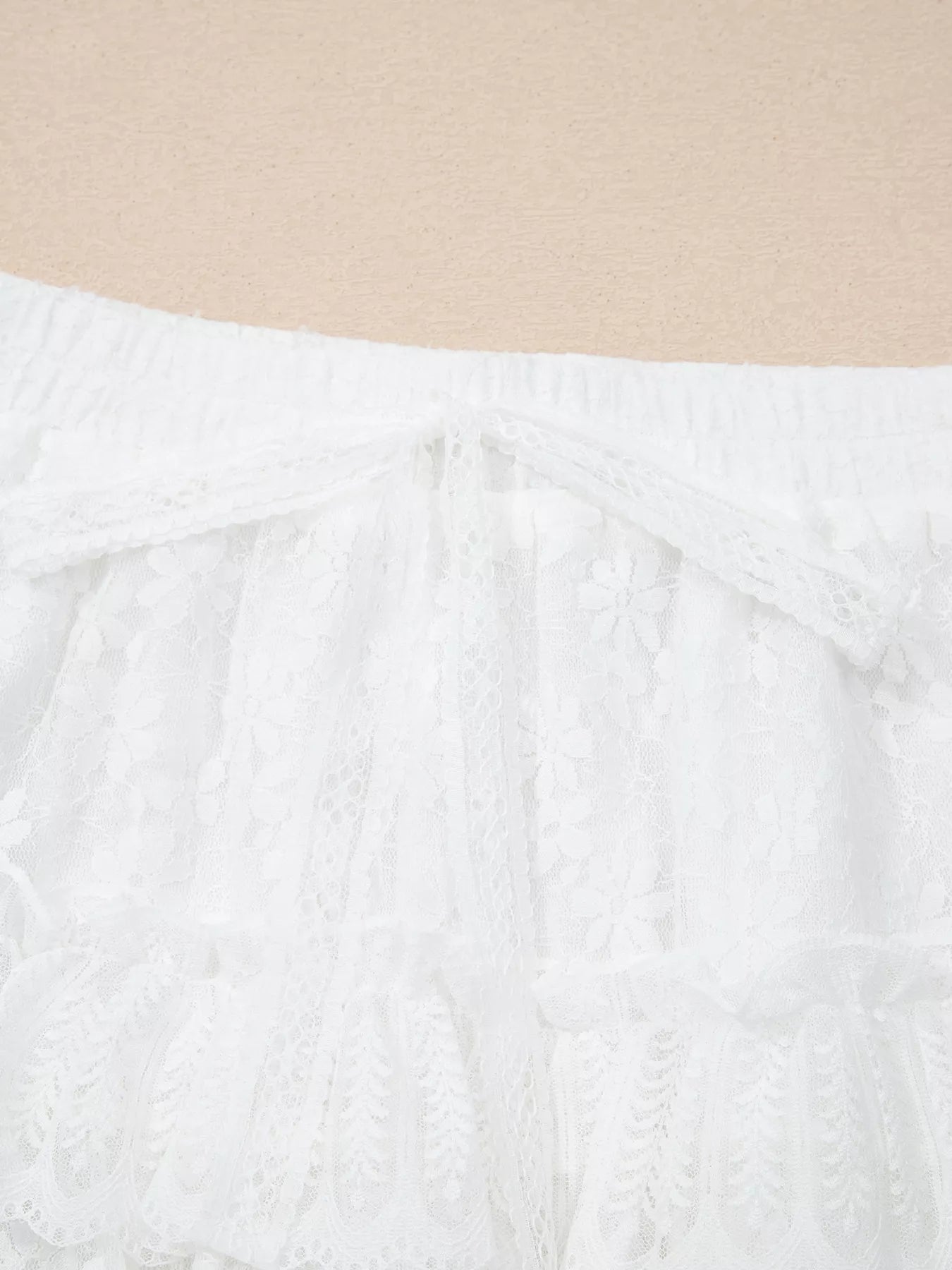 Close-up of a textured white fabric with a beige background