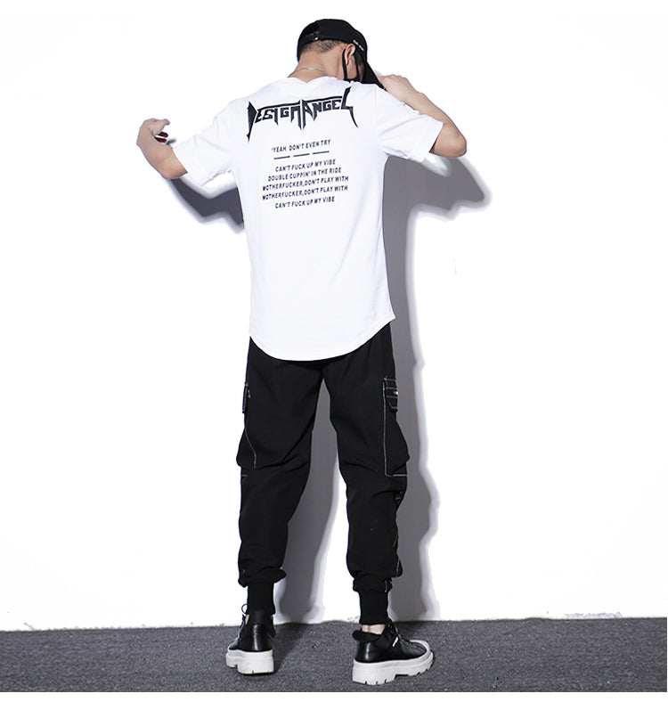 Person wearing a white t-shirt with text on the back and black pants against a white background