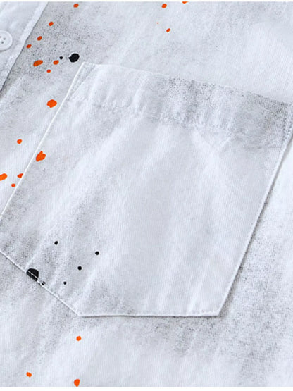 Close-up of a white shirt with orange and black dot pattern on a light gray background