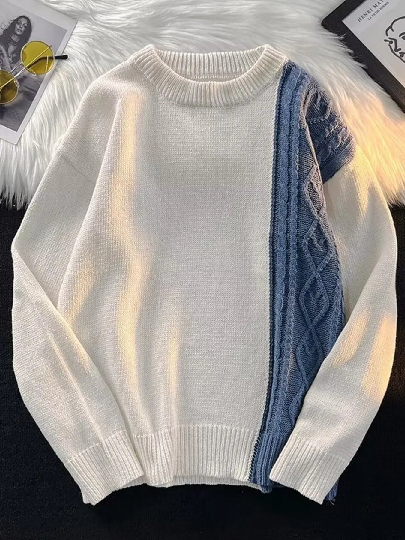 White sweater with blue patterned sleeve on a white background