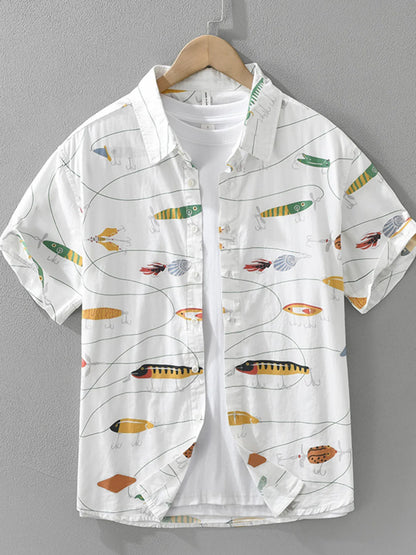 White shirt with colorful fish pattern on a hanger against a gray background