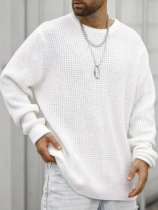 Person wearing a white textured sweater and light gray pants against a neutral background