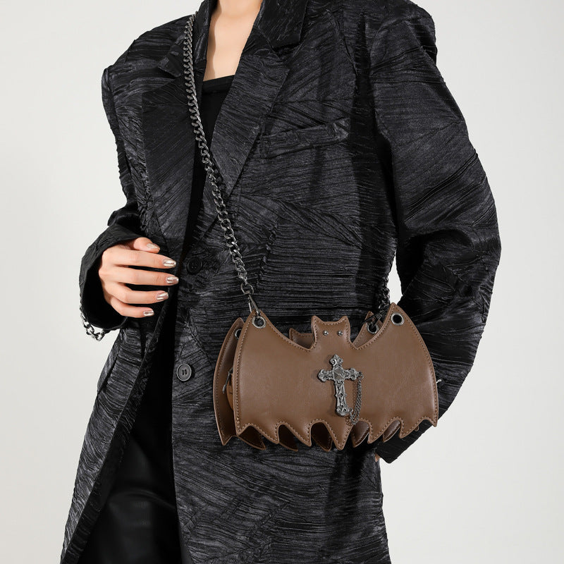 Handbag shaped as a bat being worn on a white background.