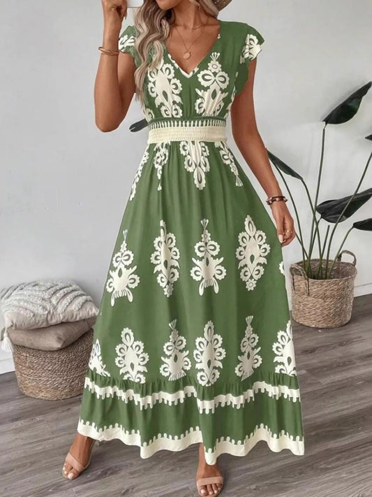 Woman wearing a green dress with white patterns in a room with a plant and basket.