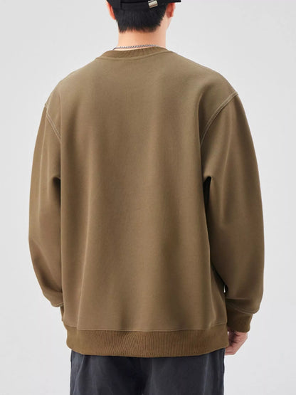 Person wearing a brown sweatshirt on a plain background