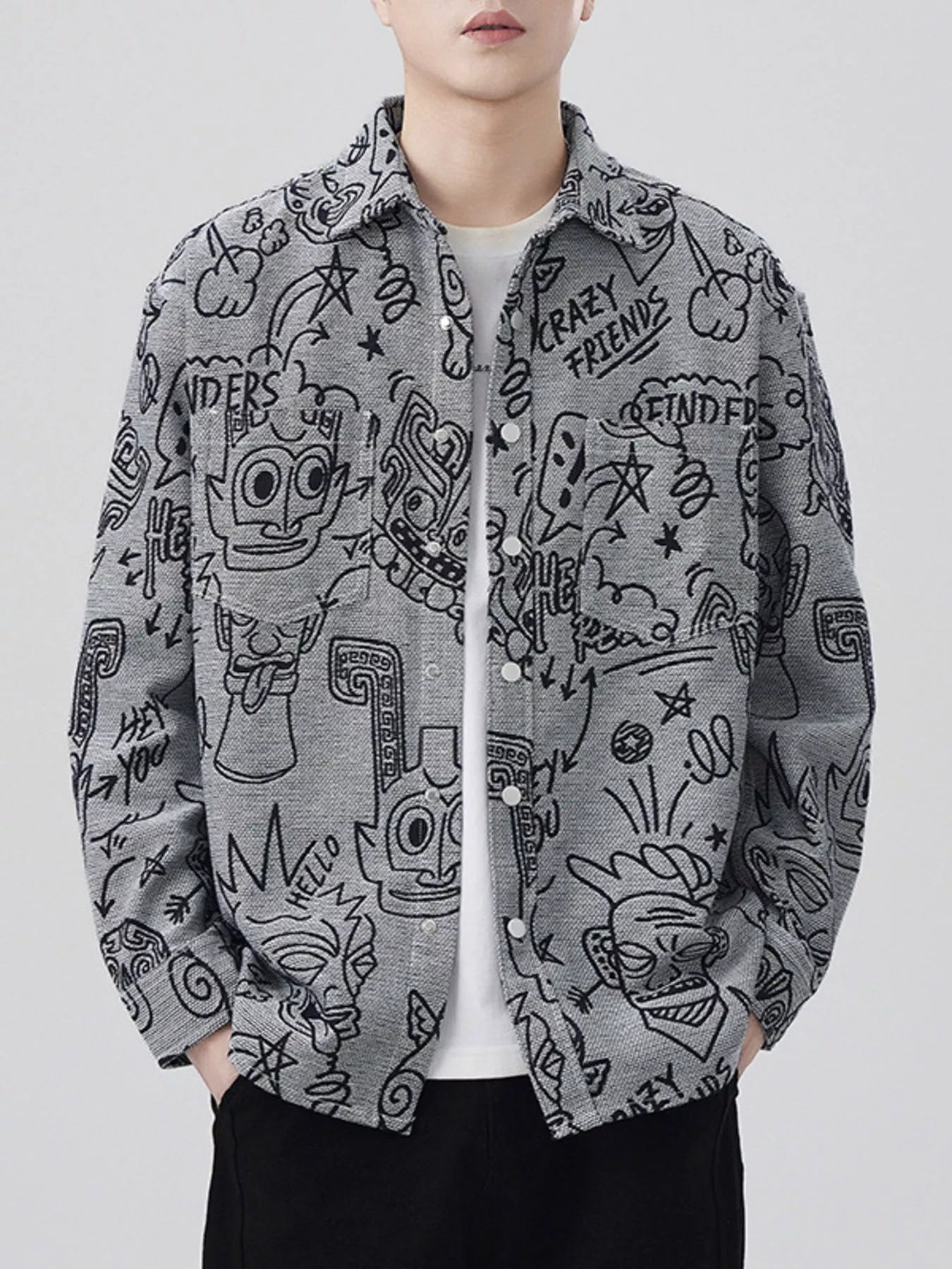 Person wearing a gray shirt with black doodle designs on a white background