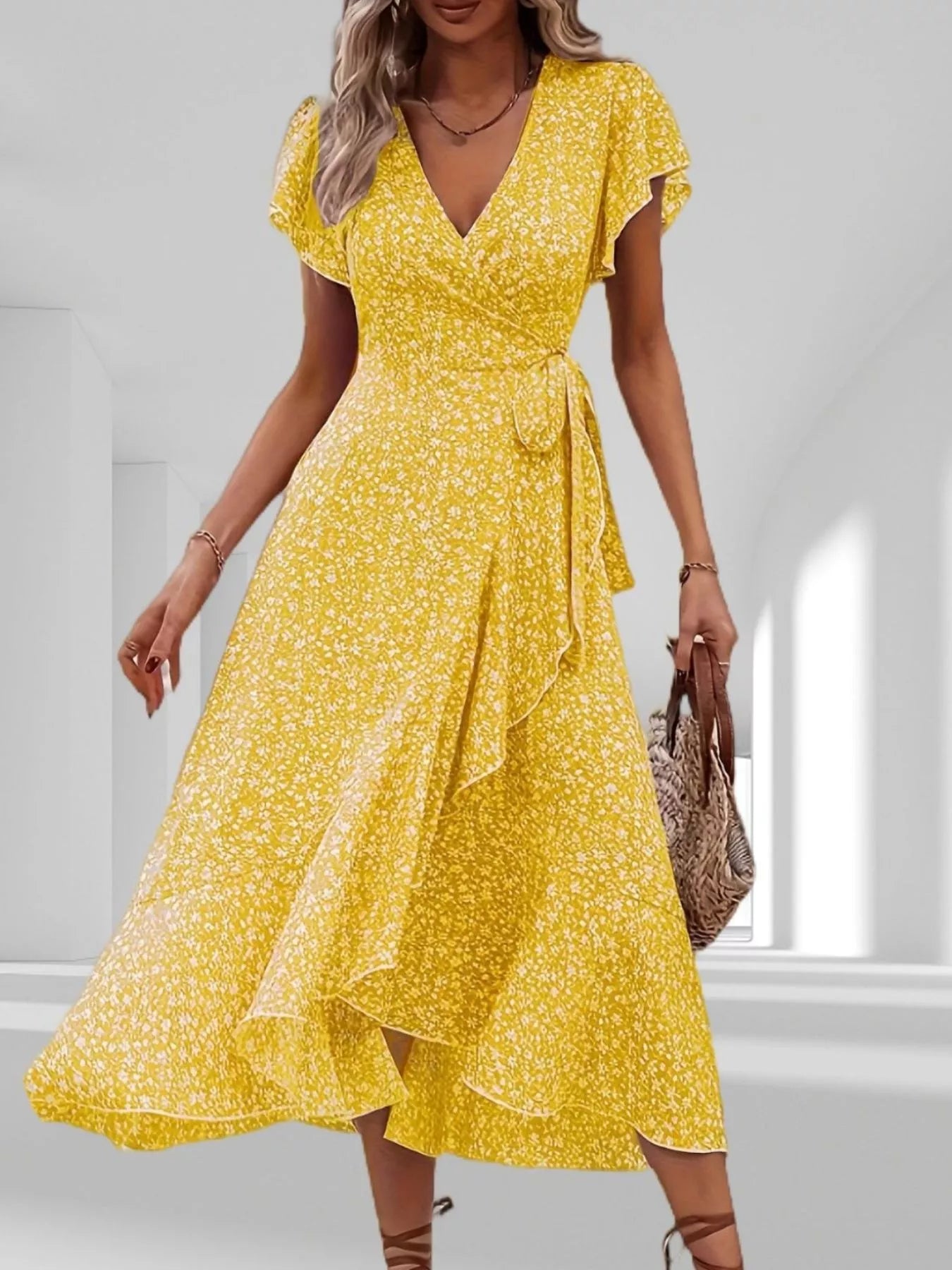 Woman wearing a yellow floral dress in a bright room