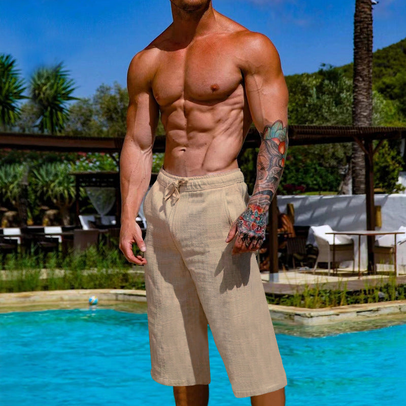 Man with tattoos standing by a pool with a scenic background