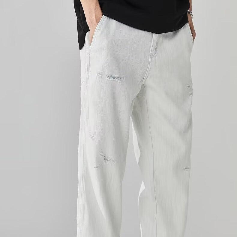 Light gray jeans worn by a person on a gray background