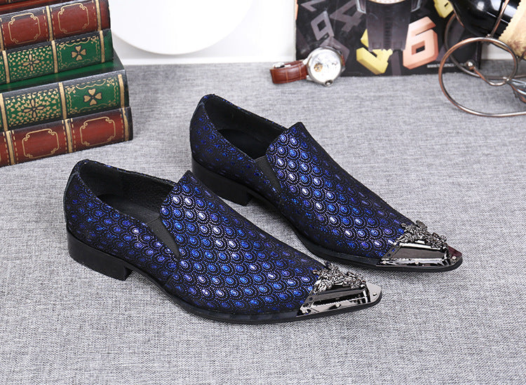 Blue patterned loafers with decorative metal accents on a gray surface.