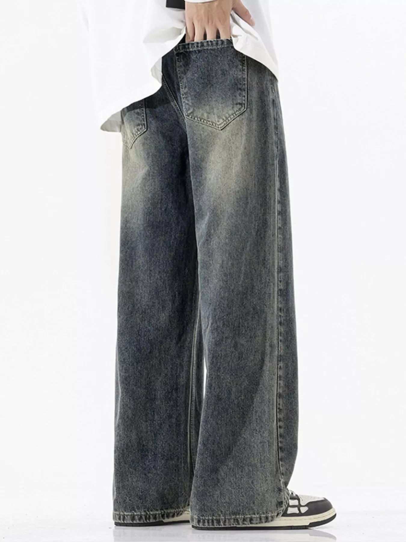 Person wearing wide-leg jeans on a white background