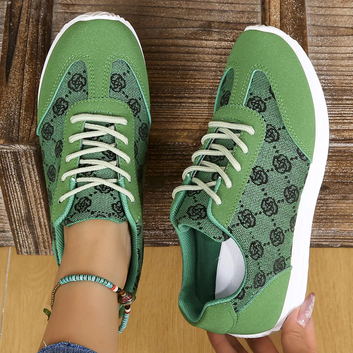 Green sneakers with white soles on a wooden floor