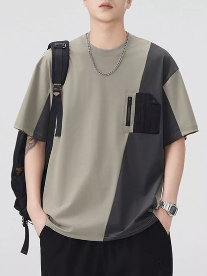 Person wearing a patchwork t-shirt with a backpack on a plain background