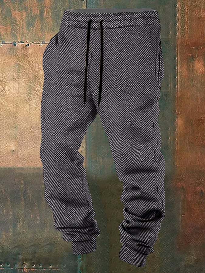 Gray herringbone-patterned pants with a drawstring on a textured brown background