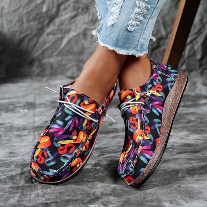 Colorful patterned shoes worn with denim jeans on a gray surface
