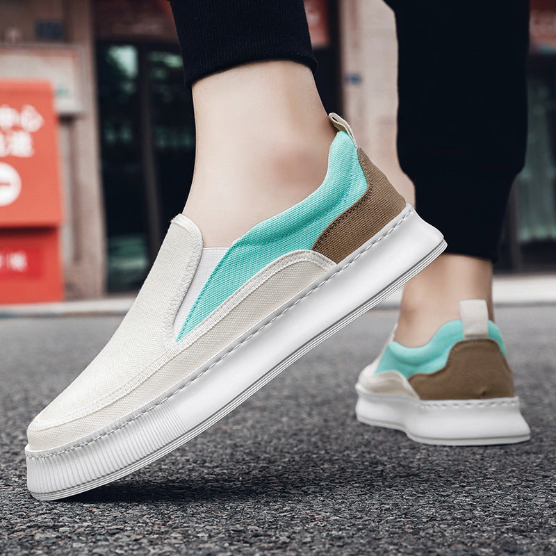 White sneakers with turquoise and brown accents worn on a street.