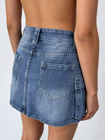 Blue denim skirt worn by a person on a white background.