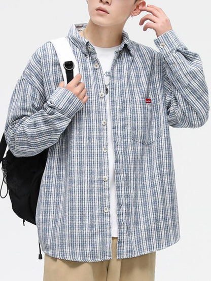 Person wearing a blue and white checkered shirt with a backpack on a plain background