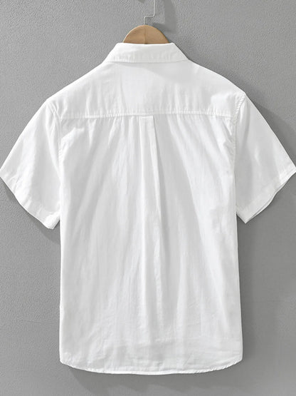 White short-sleeve shirt on a hanger against a gray background