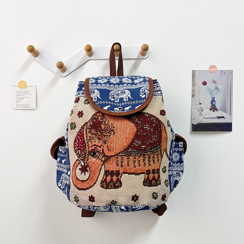Backpack with elephant design hanging on a wall hook