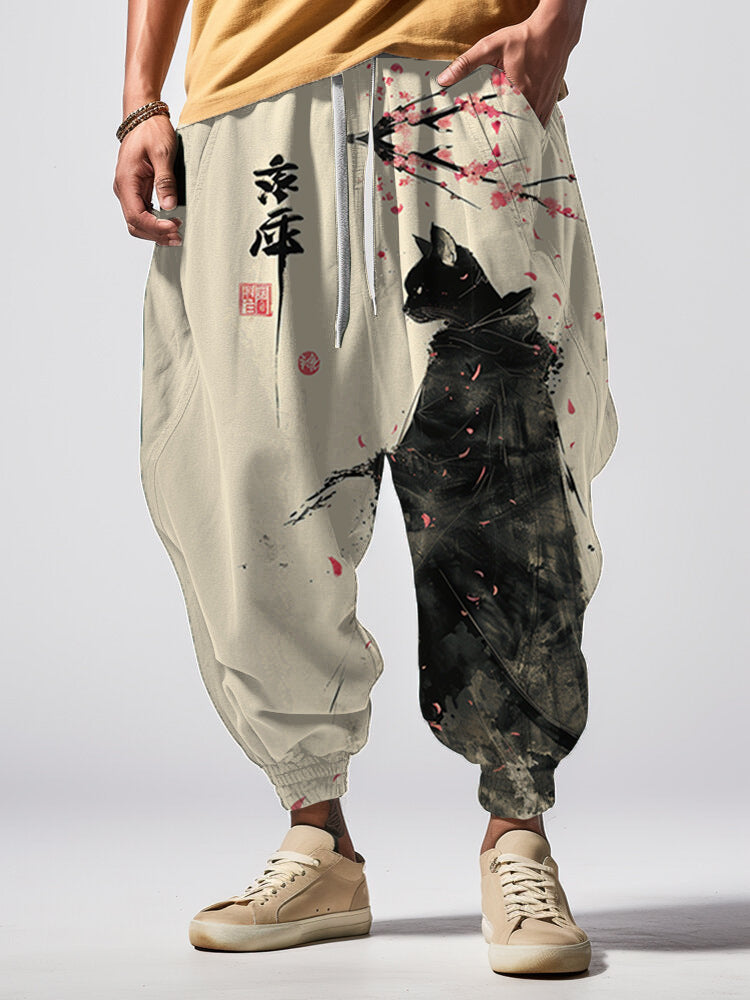Person wearing a pair of traditional-style pants with artistic designs and text on a plain background