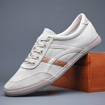 White sneaker with brown accent on a wooden block against a gray background