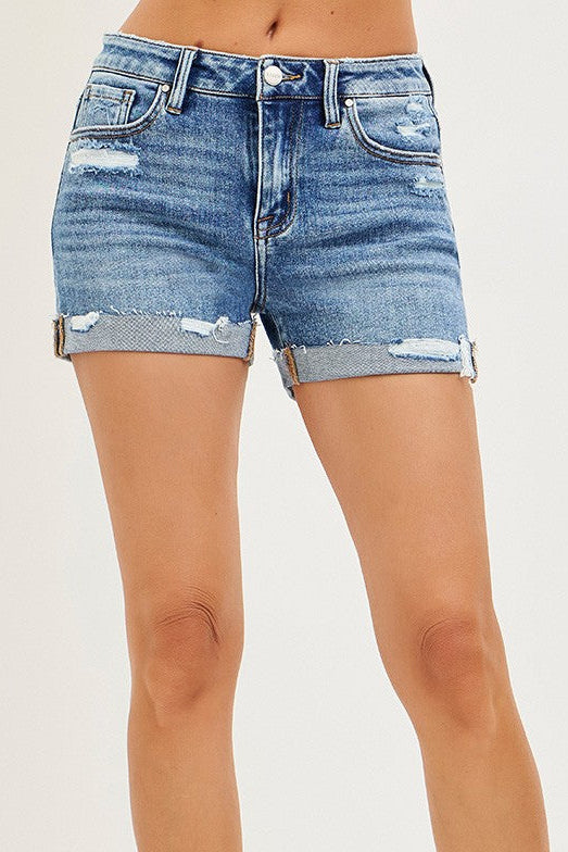Denim shorts with a distressed look worn by a person on a white background