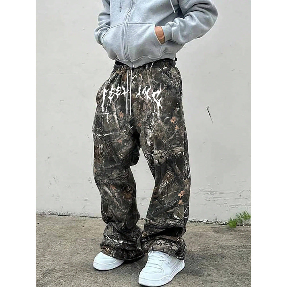 Person wearing camouflage sweat pants against a plain white wall.
