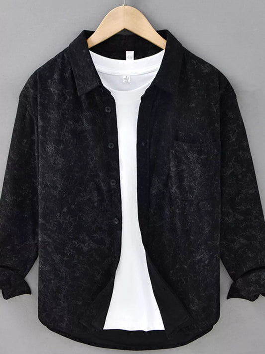 Black textured shirt over a white shirt on a hanger against a gray background