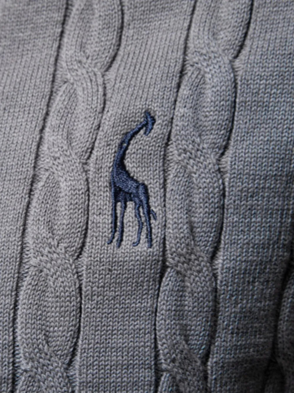 Gray cable knit sweater with a blue embroidered giraffe design.