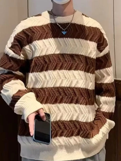 Person wearing a brown and white striped sweater holding a phone.