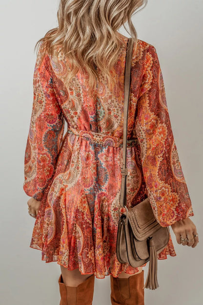 Person wearing a patterned dress with long sleeves and brown boots, holding a brown handbag.