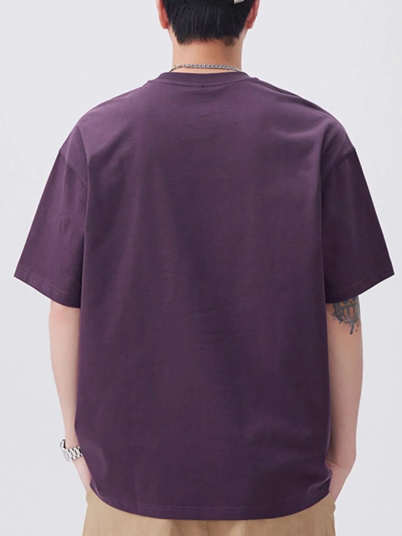 Person wearing a purple t-shirt on a plain background