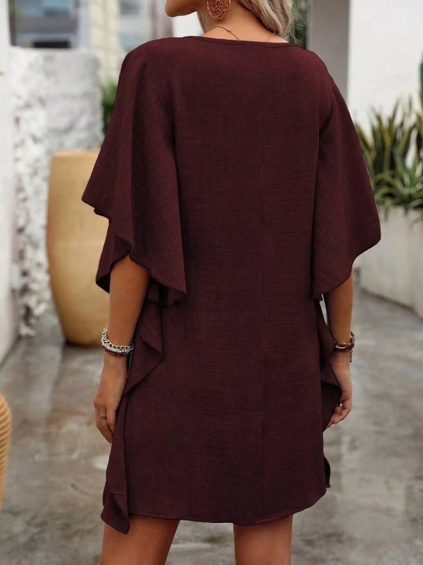 Burgundy dress worn by a person with a blurred background