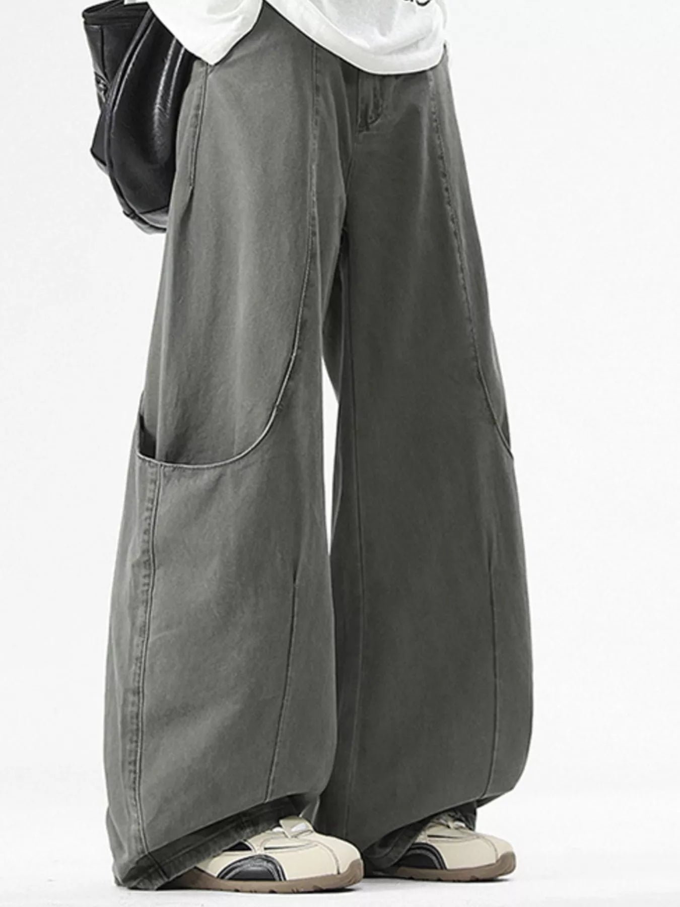 Person wearing wide-leg gray pants on a white background