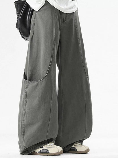 Person wearing wide-leg gray pants on a white background