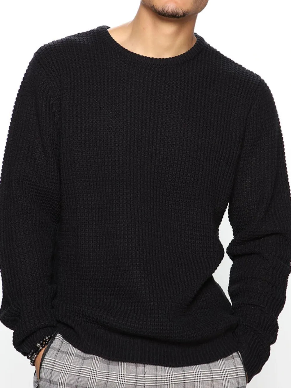 Person wearing a black sweater on a white background