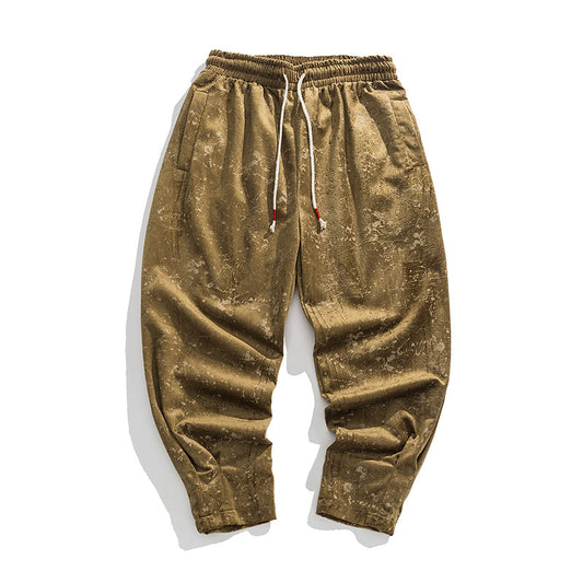 Gold velvet jogger pants on a white background